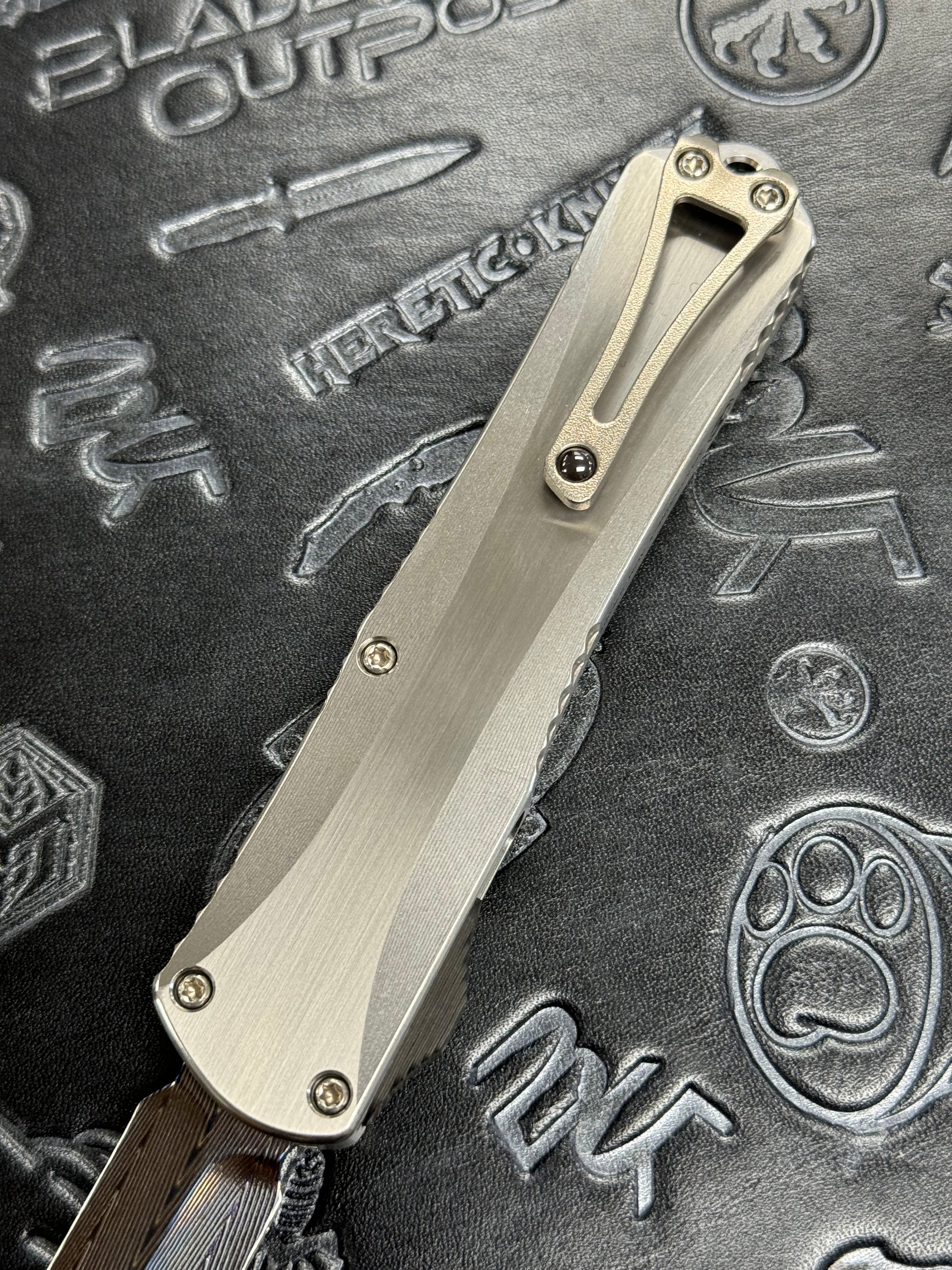 Pre Owned Heretic Knives Custom Manticore X D/E Hand Ground Vegas Forged Damascus, Hefted Stainless Steel Handle, Orange Peel Clip, Deep Engrave Logo, Carbon Fiber Button SN:007