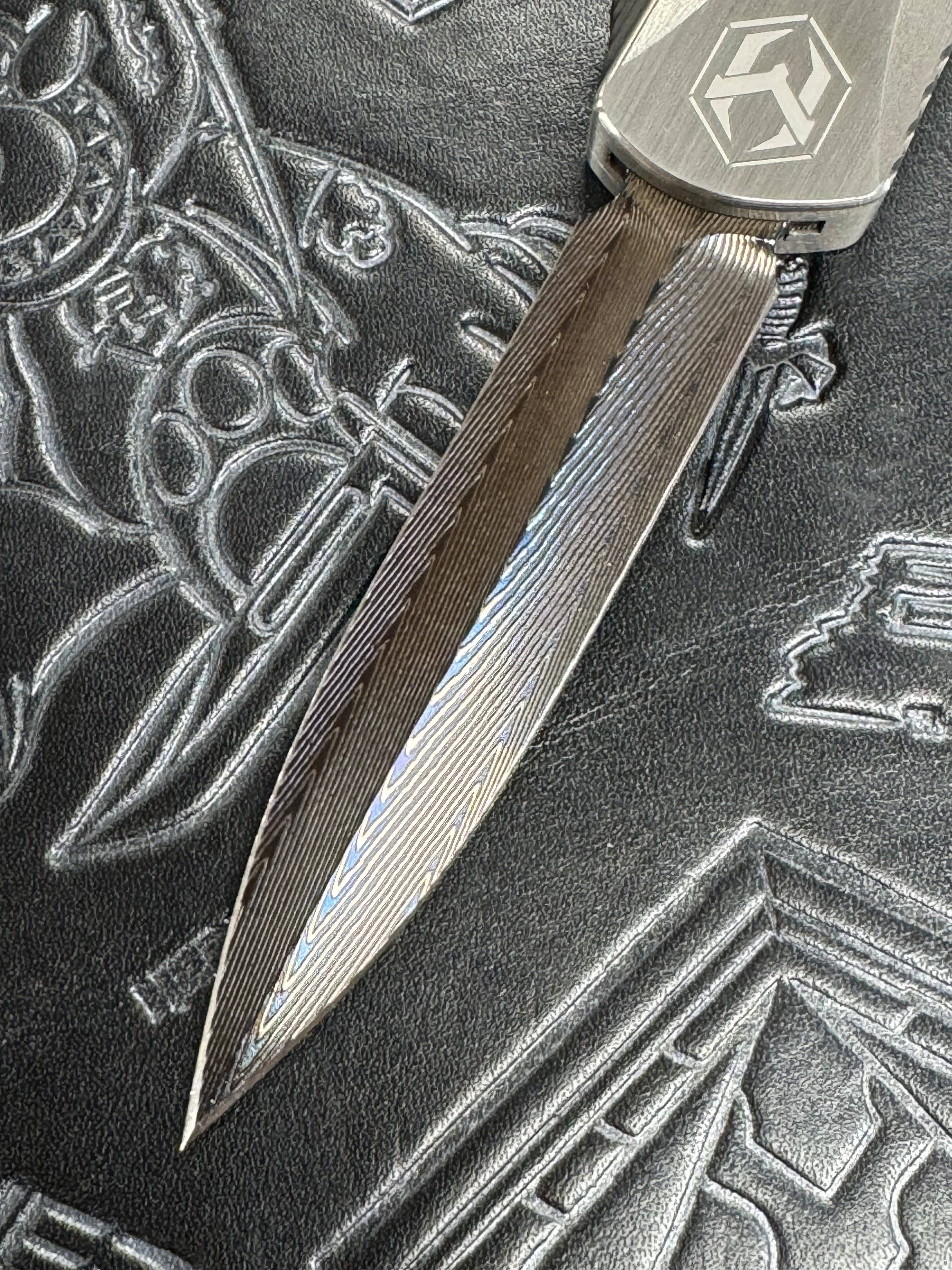 Pre Owned Heretic Knives Custom Manticore X D/E Hand Ground Vegas Forged Damascus, Hefted Stainless Steel Handle, Orange Peel Clip, Deep Engrave Logo, Carbon Fiber Button SN:007