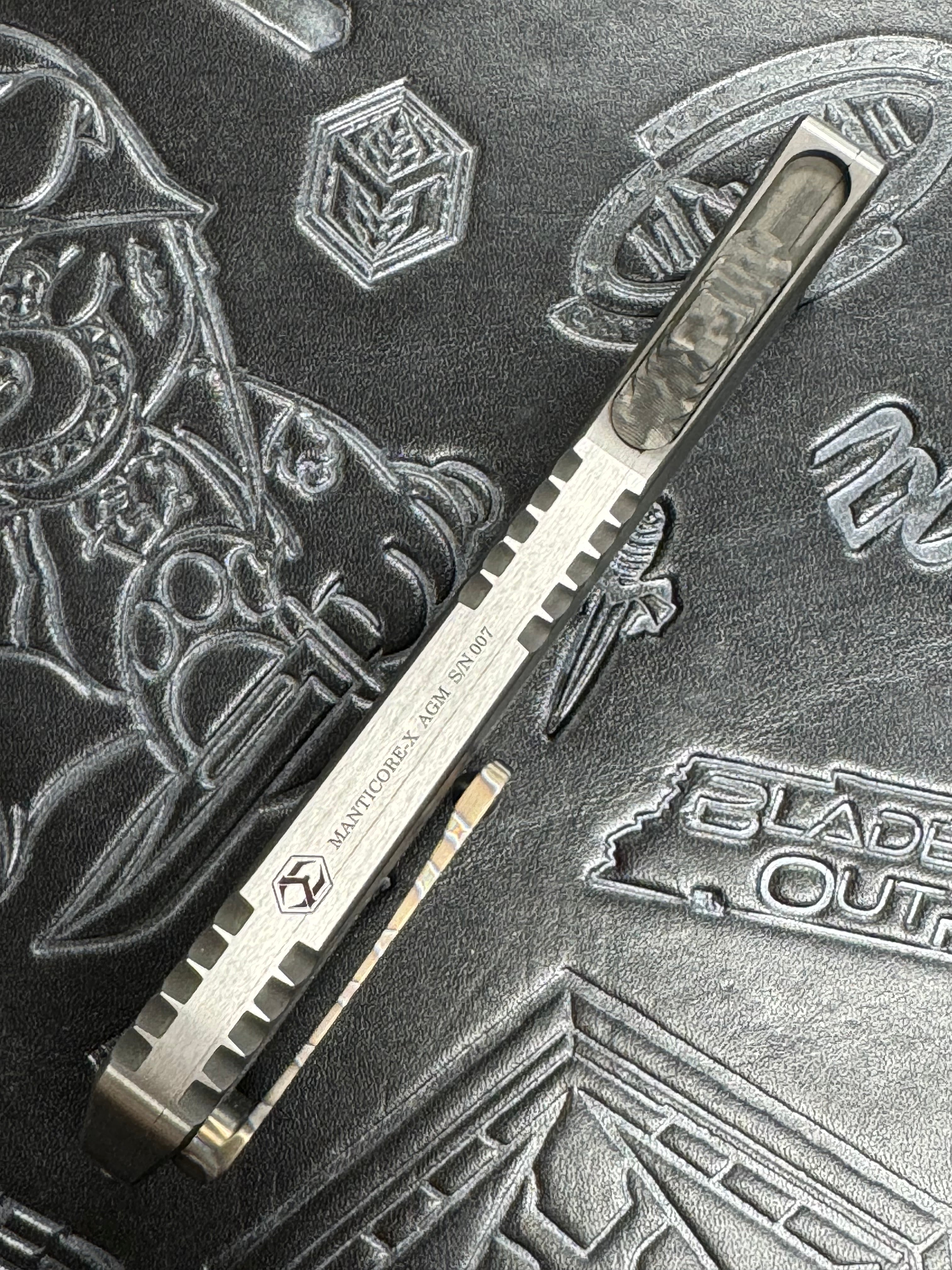 Pre Owned Heretic Knives Manticore X Hand Ground Vegas Forge Damascus DLC D/E & Two Tone DLC Hefted Stainless Steel Handle with Flamed Clip & CF Button