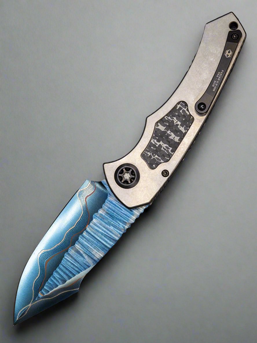 Pre Owned HERETIC KNIVES CUSTOM PARIAH- OTS AUTO- TITANIUM FRAME- FAT CARBON SNAKESKIN INLAY- BLUED BAKER FORGE ELITE AURORAMAI DAMASCUS BLADE- FAT CARBON SNAKESKIN BUTTON INLAY