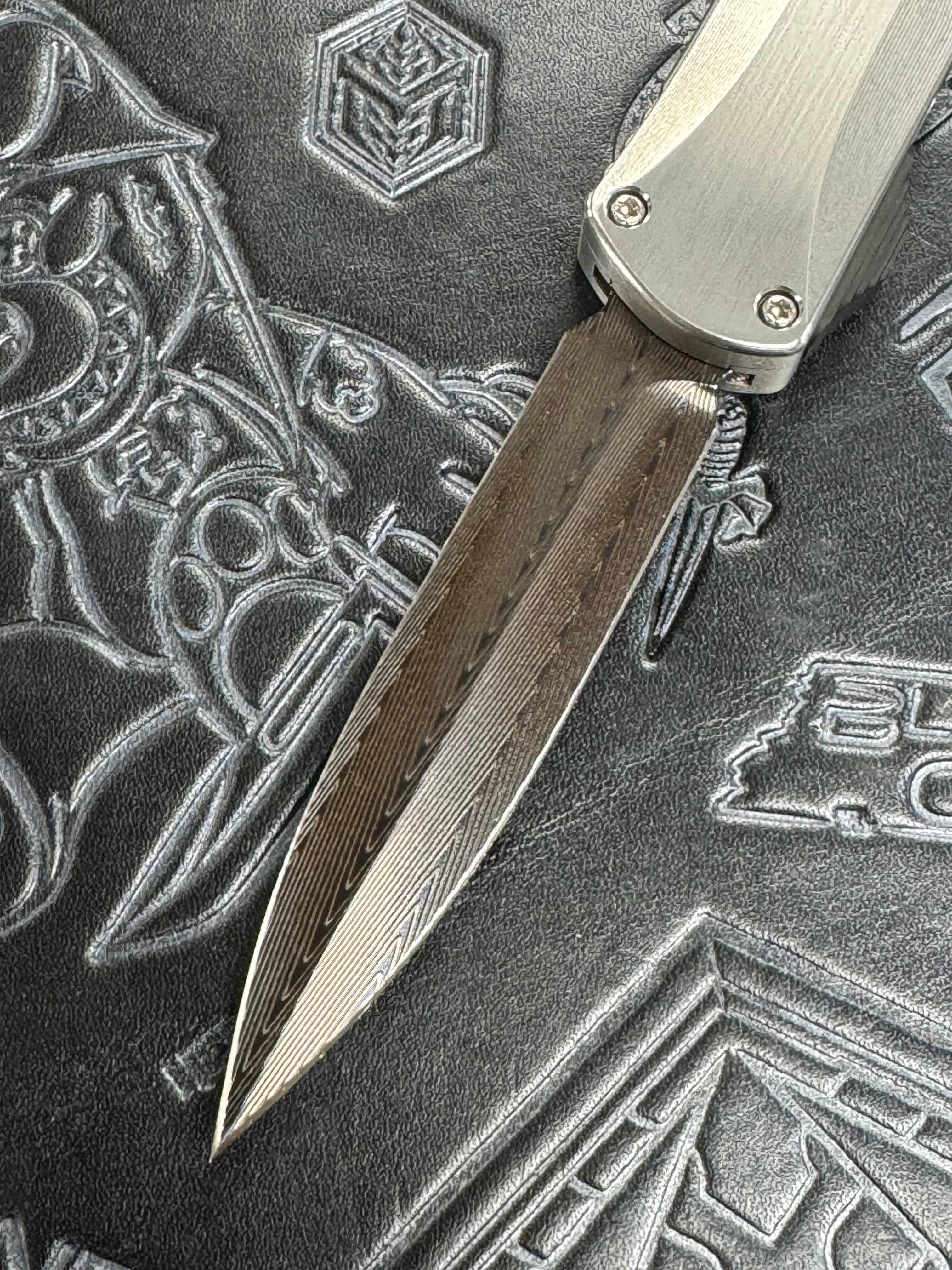 Pre Owned Heretic Knives Custom Manticore X D/E Hand Ground Vegas Forged Damascus, Hefted Stainless Steel Handle, Orange Peel Clip, Deep Engrave Logo, Carbon Fiber Button SN:007