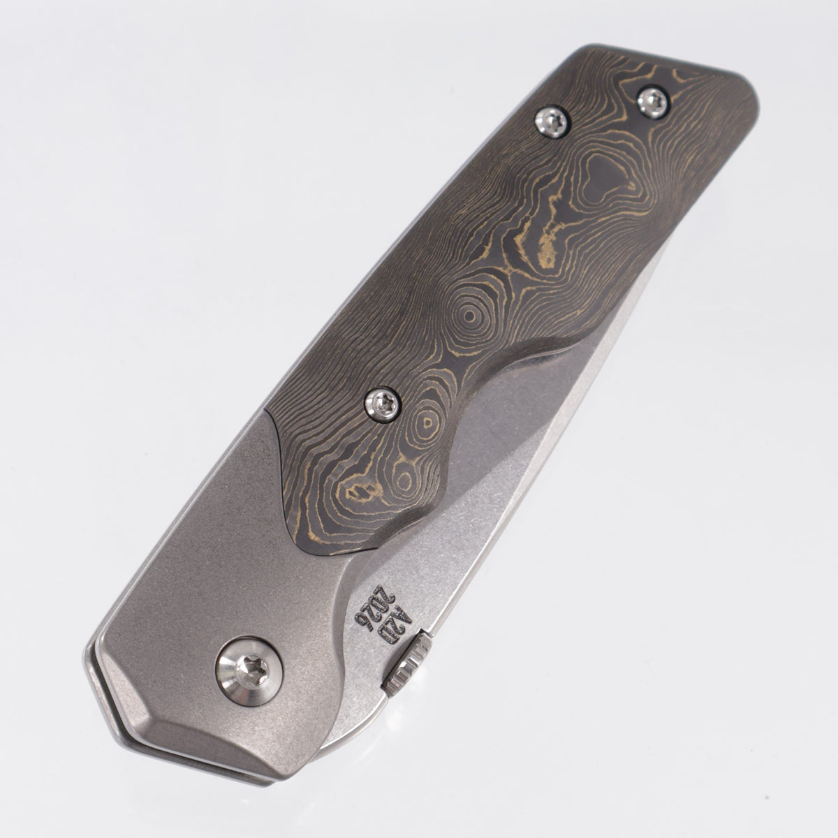 Attn2Detail Mercantile Mk.3 Medium Bolster Lock Gen4 Drop Point Rising Grind - Grey Stonewash Titanium w/ Brass Fukugo Fat Carbon Scales - Stonewash Satin Magnacut