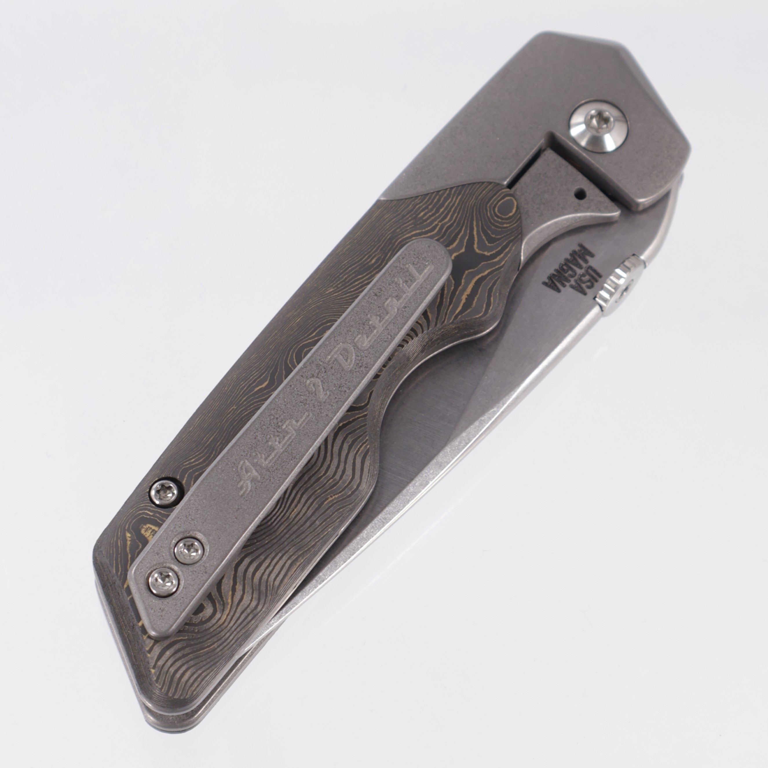 Attn2Detail Mercantile Mk.3 Medium Bolster Lock Gen4 Drop Point Rising Grind - Grey Stonewash Titanium w/ Brass Fukugo Fat Carbon Scales - Stonewash Satin Magnacut