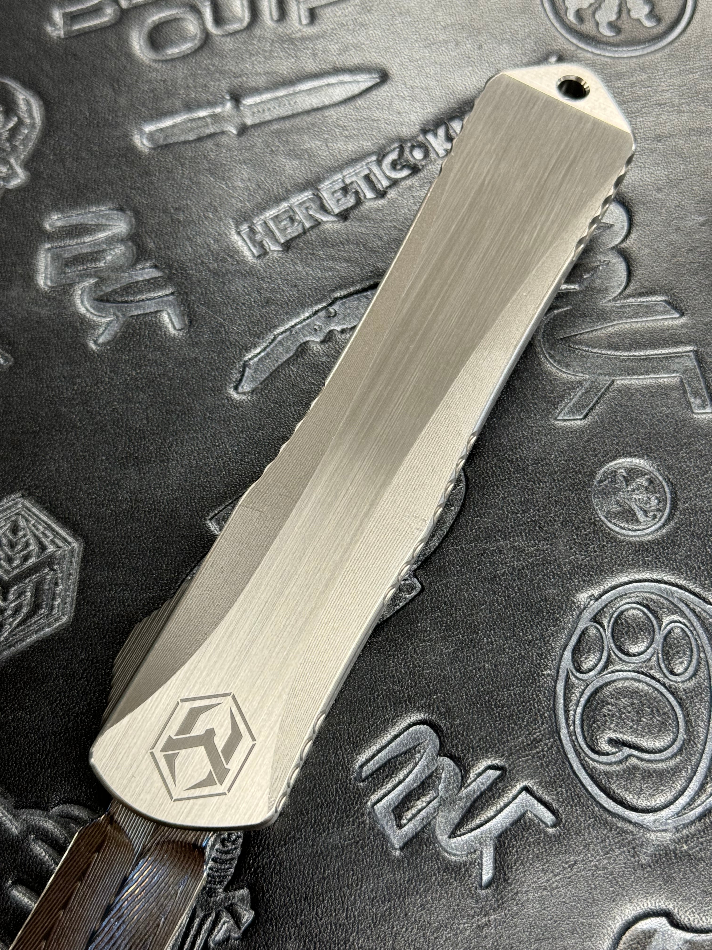 Pre Owned Heretic Knives Custom Manticore X D/E Hand Ground Vegas Forged Damascus, Hefted Stainless Steel Handle, Orange Peel Clip, Deep Engrave Logo, Carbon Fiber Button SN:007