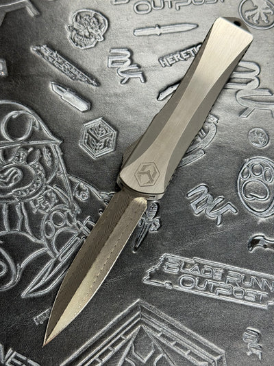 Pre Owned Heretic Knives Manticore X Hand Ground Vegas Forge Damascus DLC D/E & Two Tone DLC Hefted Stainless Steel Handle with Flamed Clip & CF Button