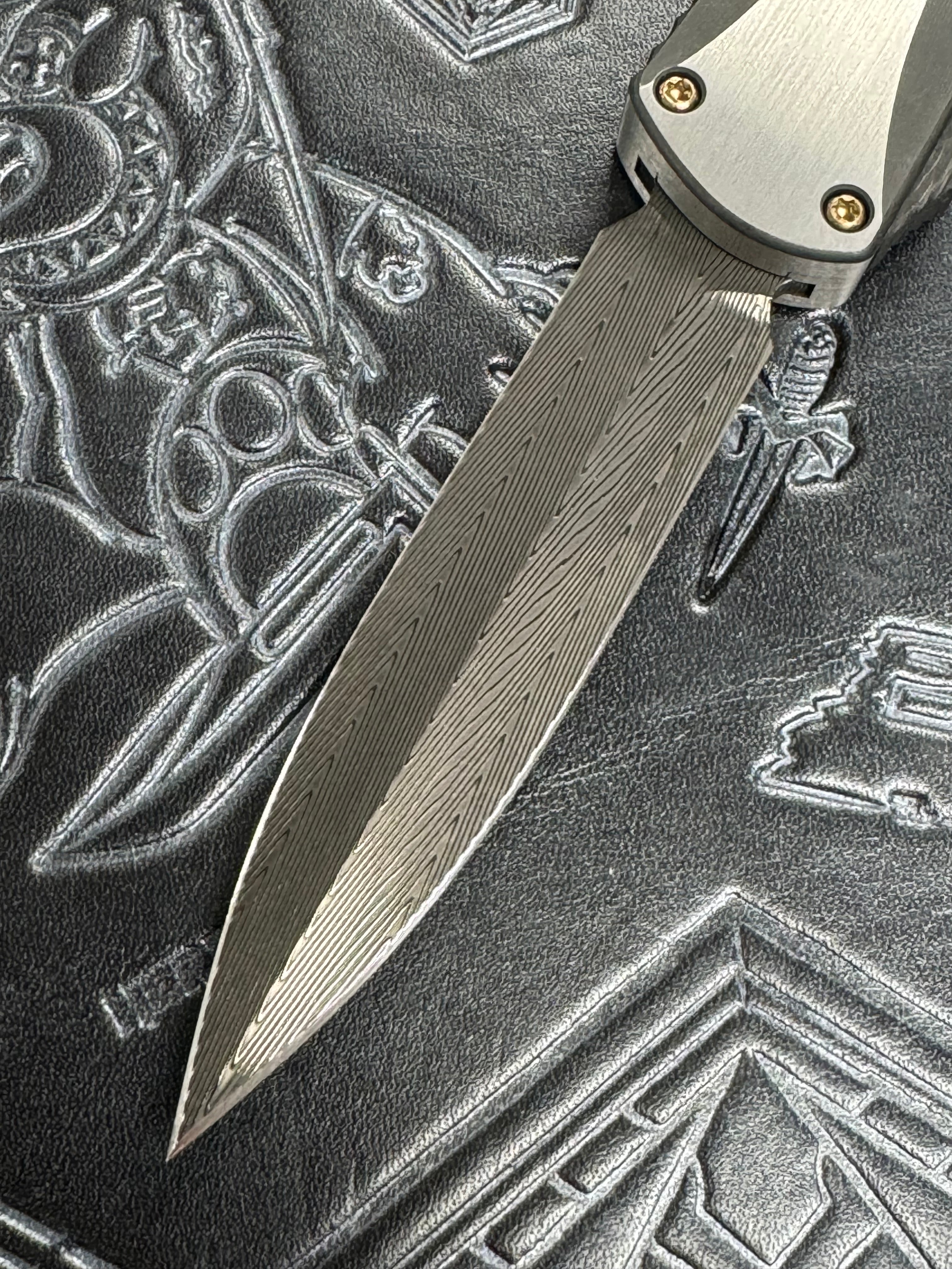 Pre Owned Heretic Knives Manticore X Hand Ground Vegas Forge Damascus DLC D/E & Two Tone DLC Hefted Stainless Steel Handle with Flamed Clip & CF Button