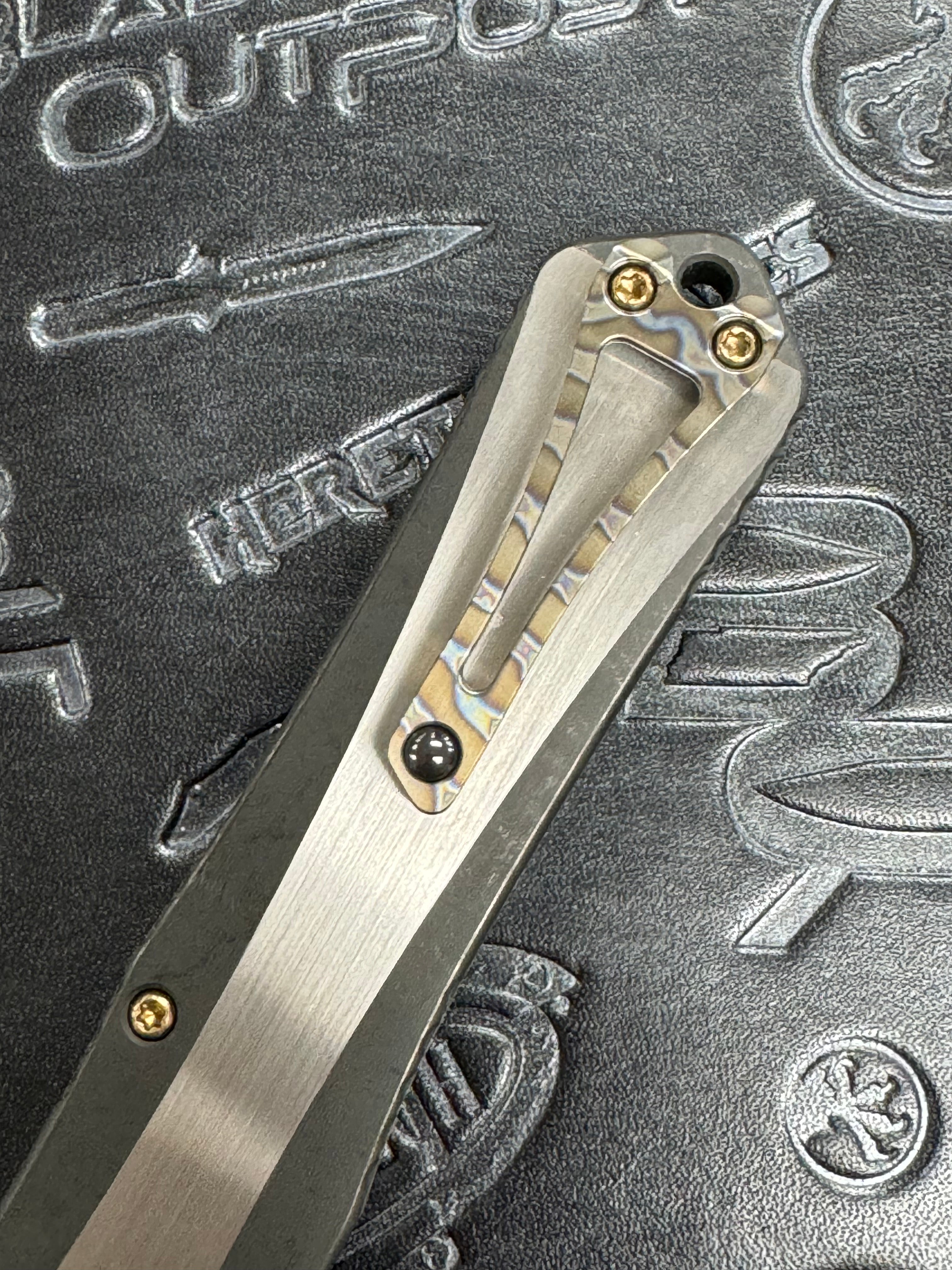 Pre Owned Heretic Knives Manticore X Hand Ground Vegas Forge Damascus DLC D/E & Two Tone DLC Hefted Stainless Steel Handle with Flamed Clip & CF Button