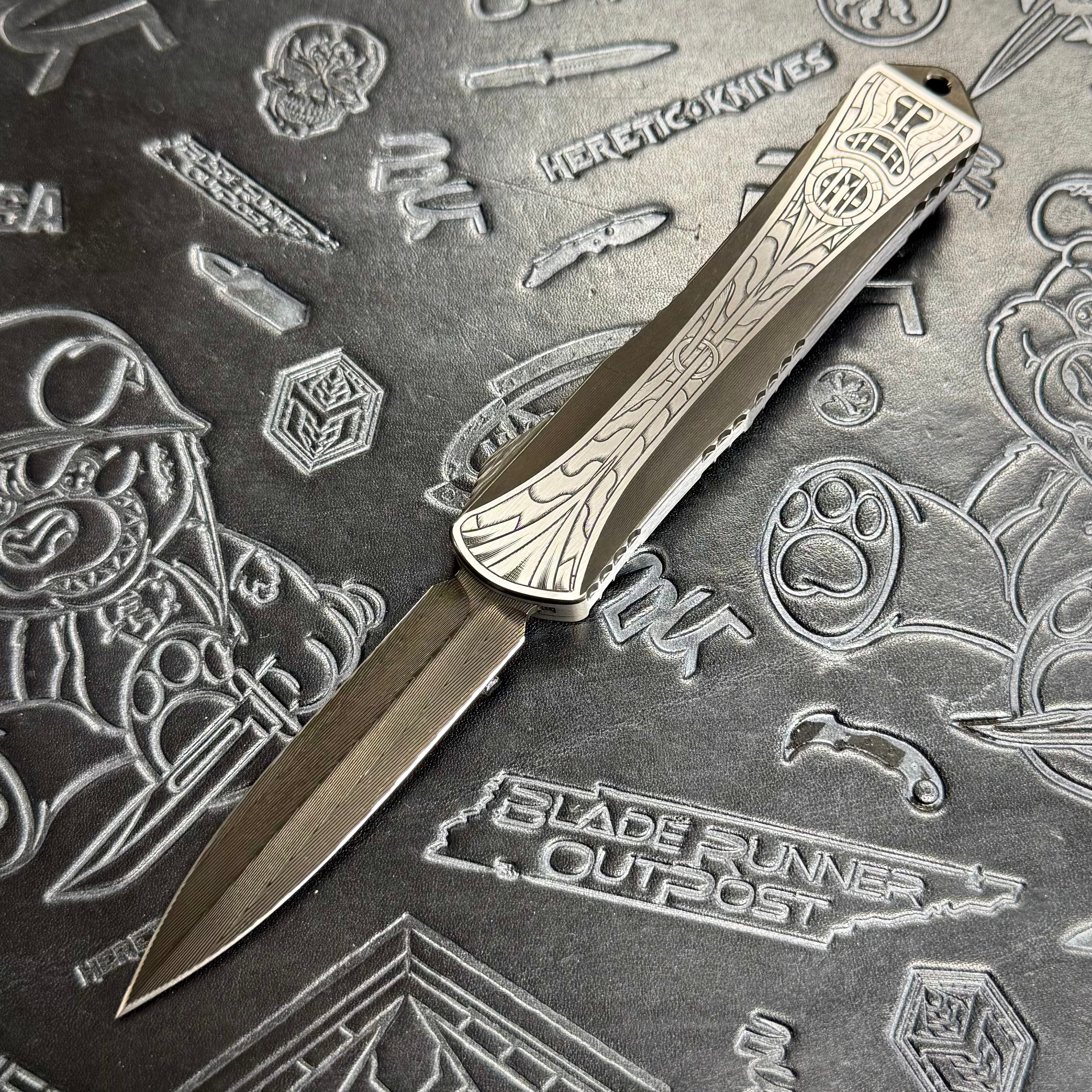 Heretic Manticore X Custom - Hand Engraved - Hand Ground DLC Vegas Forge Damascus Double Edge - 2 tone Hefted DLC stainless chassis - Flamed Ti Clip - Carbon Fiber Button S/N: 010