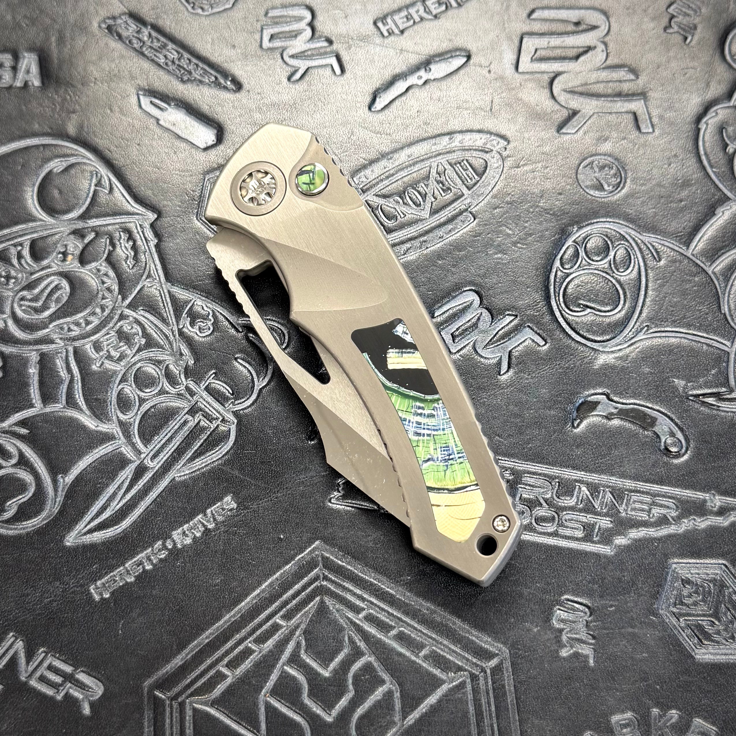 Heretic Pariah Manual Custom - Single Cracked Ice - Hefted
Titanium Chassis w/ Green
Mammoth Inlays & Green Mammoth button inlay S/N: 006