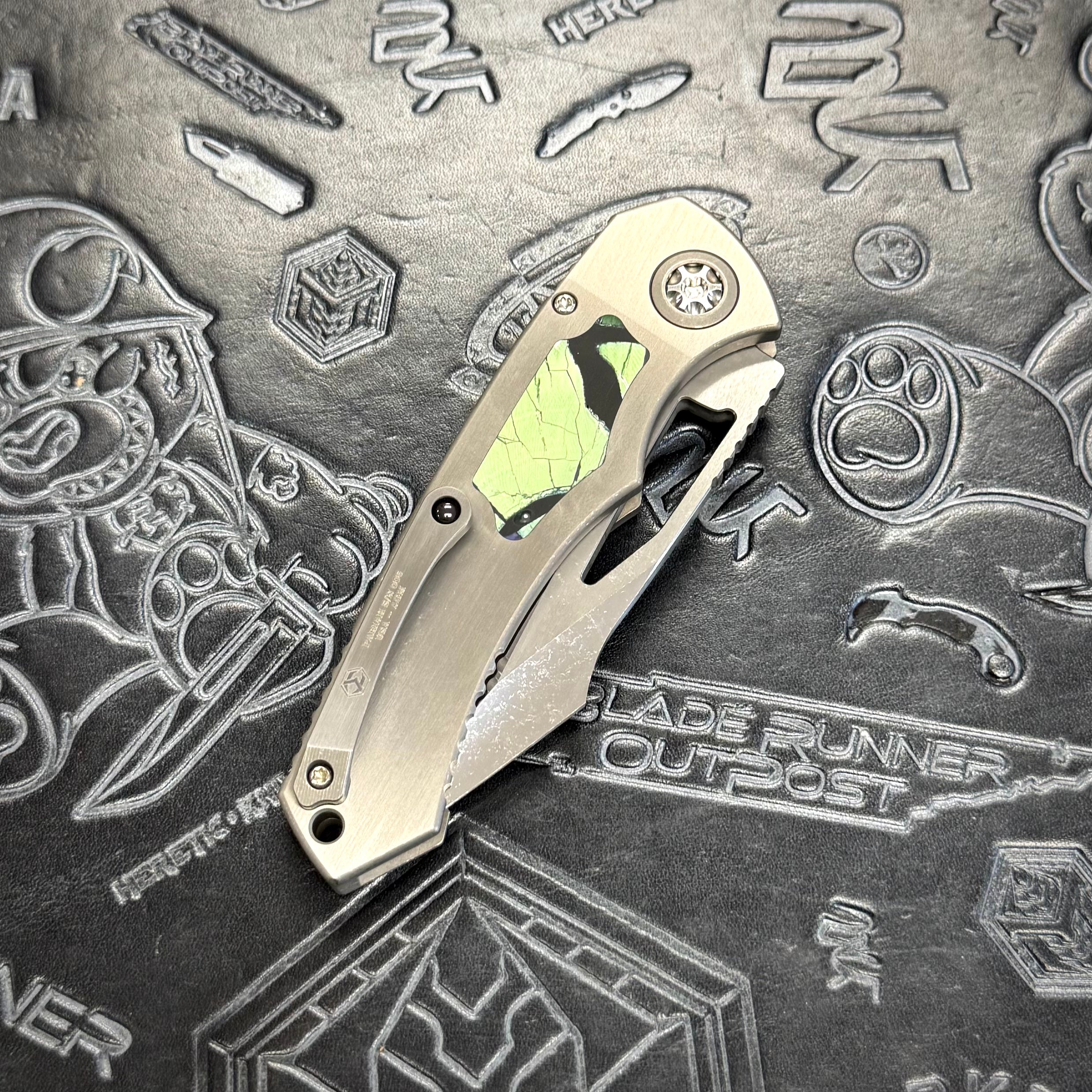 Heretic Pariah Manual Custom - Single Cracked Ice - Hefted
Titanium Chassis w/ Green
Mammoth Inlays & Green Mammoth button inlay S/N: 006