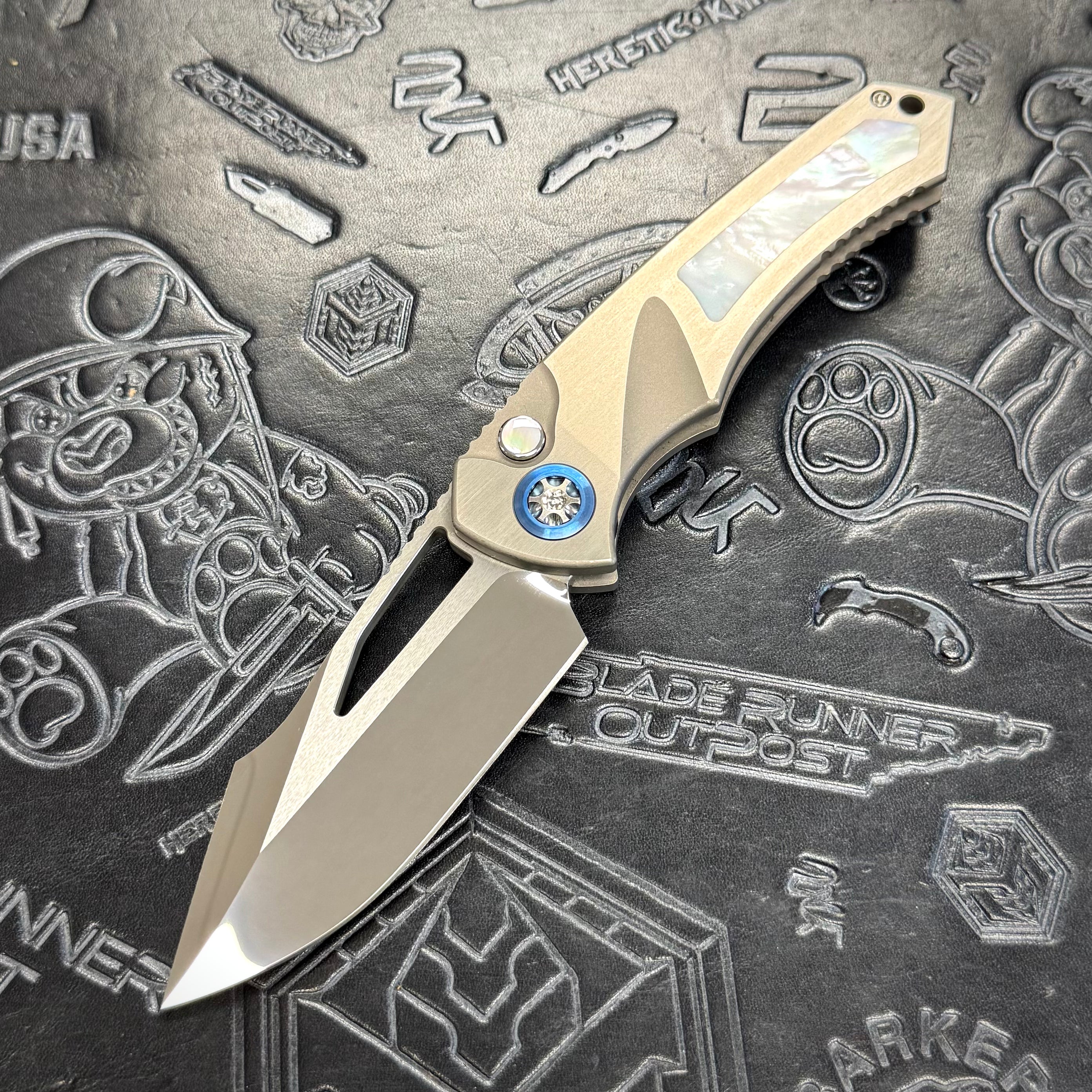 Heretic Pariah Manual Custom - Single Edge Mirror Polish - Hefted
Titanium Chassis w/ Mother of Pearl inlays & Mother of Pearl button inlay - Blue Ti pivot collars
S/N: 017
