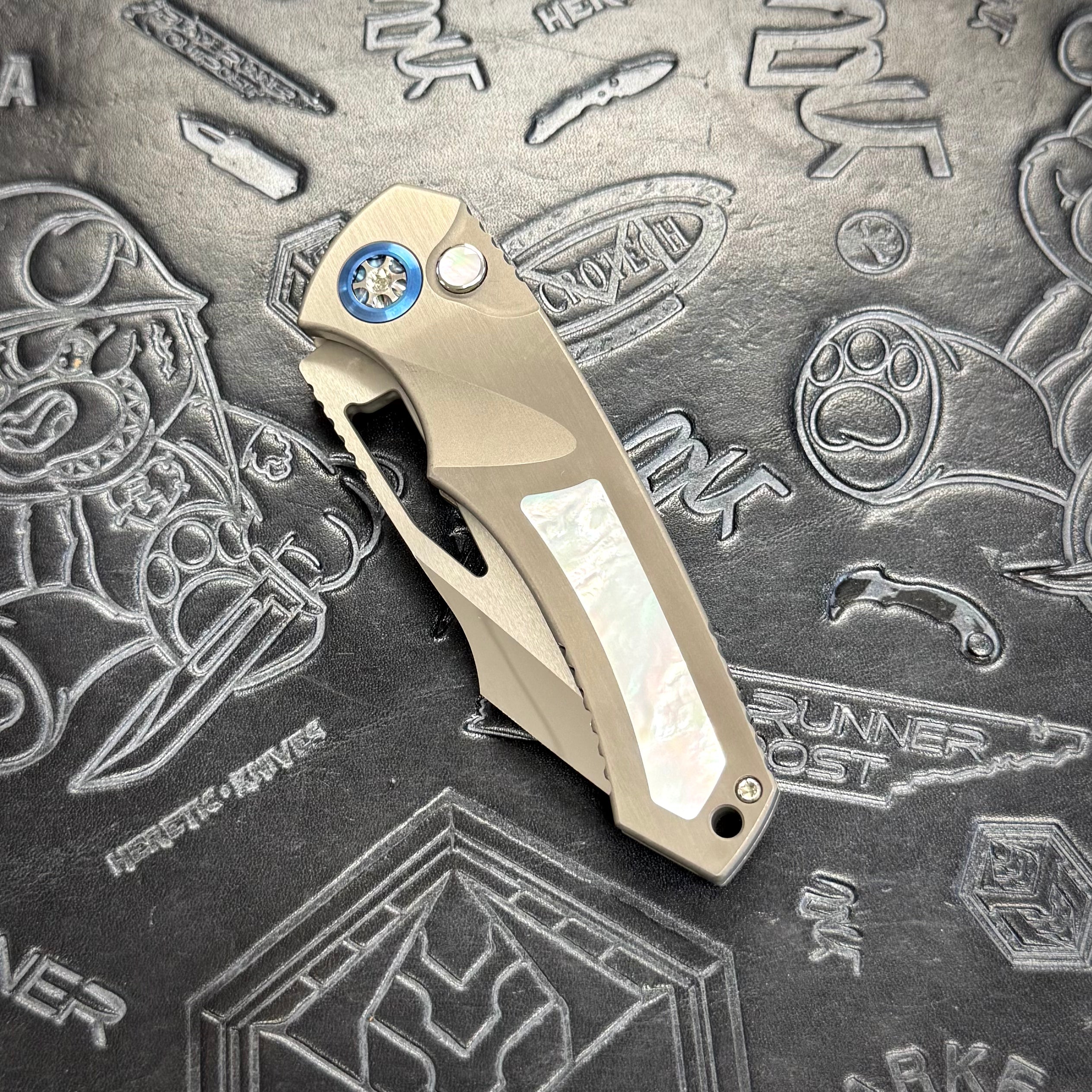 Heretic Pariah Manual Custom - Single Edge Mirror Polish - Hefted
Titanium Chassis w/ Mother of Pearl inlays & Mother of Pearl button inlay - Blue Ti pivot collars
S/N: 017