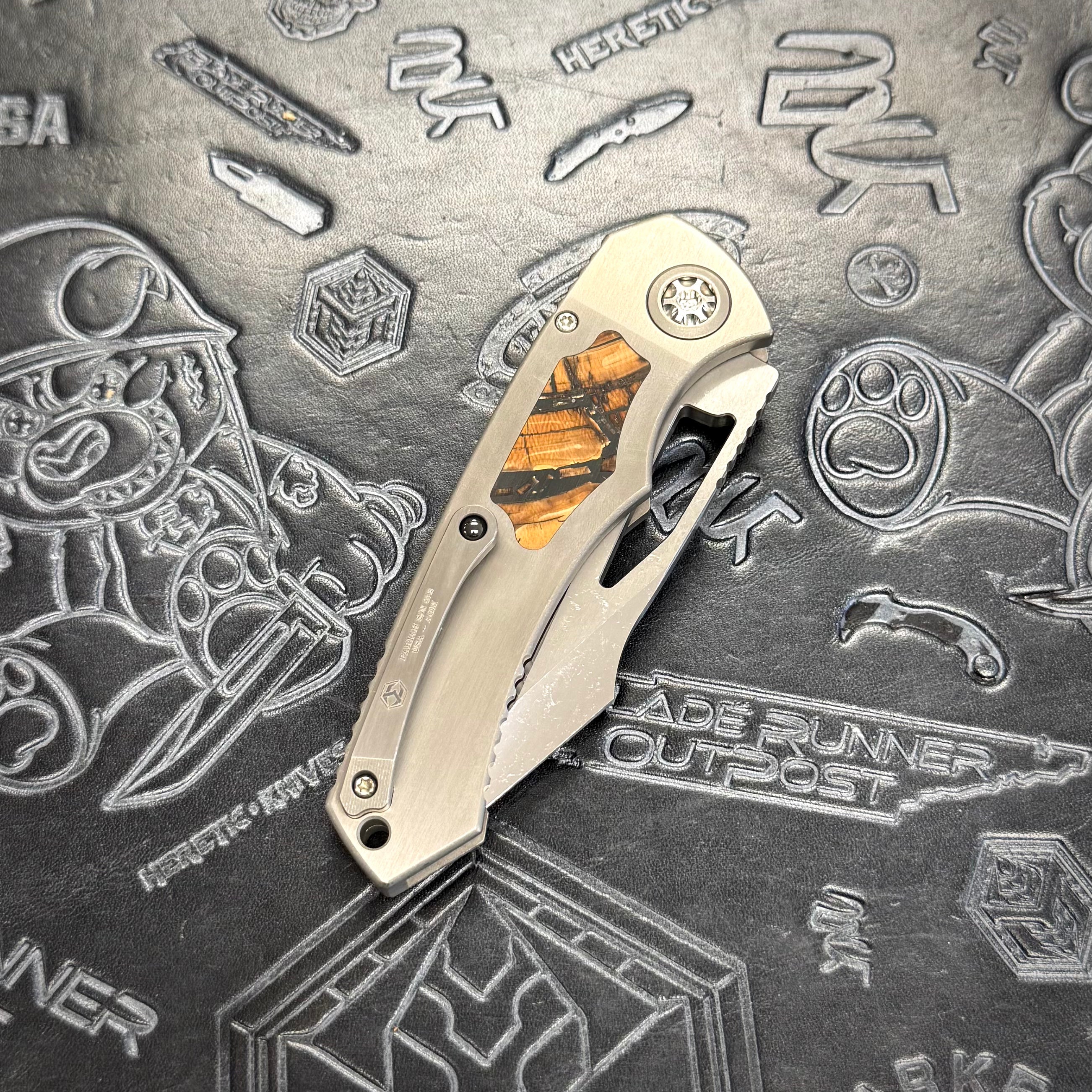 Heretic Pariah Manual Custom - Single Cracked Ice - Hefted
Titanium Chassis w/ Brown
Mammoth Inlays & Brown Mammoth button inlay S/N: 012
