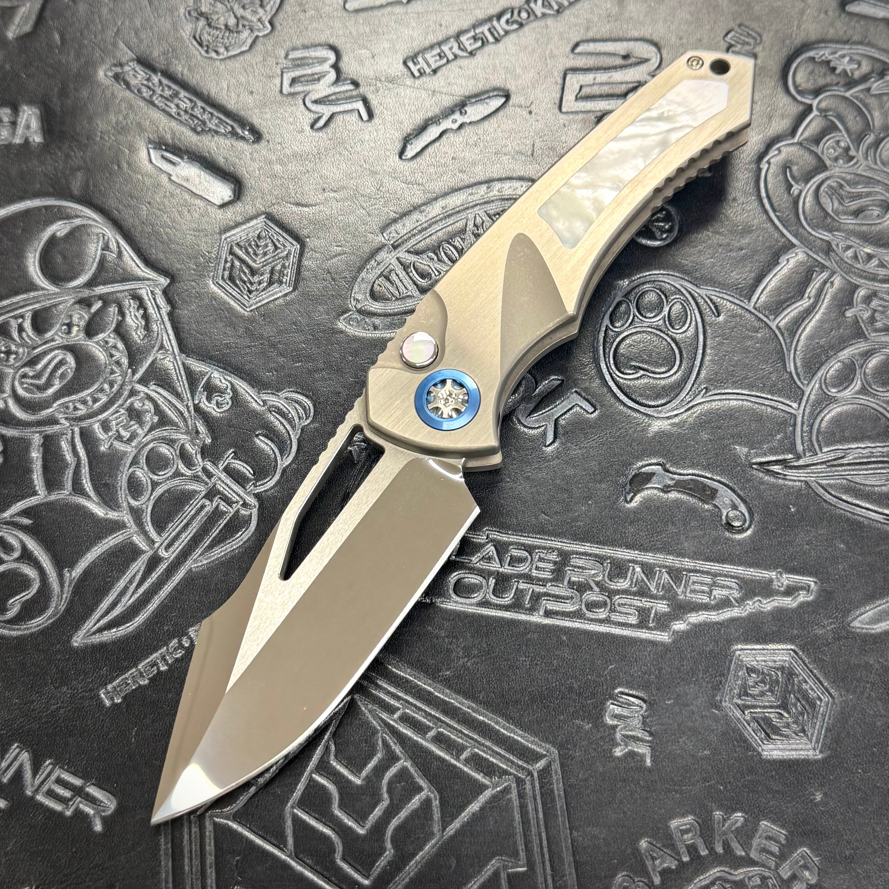 Heretic Pariah Manual Custom - Single Edge Mirror Polish - Hefted Titanium Chassis w/ Mother of Pearl inlays & Mother of Pearl button inlay - Blue Ti pivot collars
S/N: 022